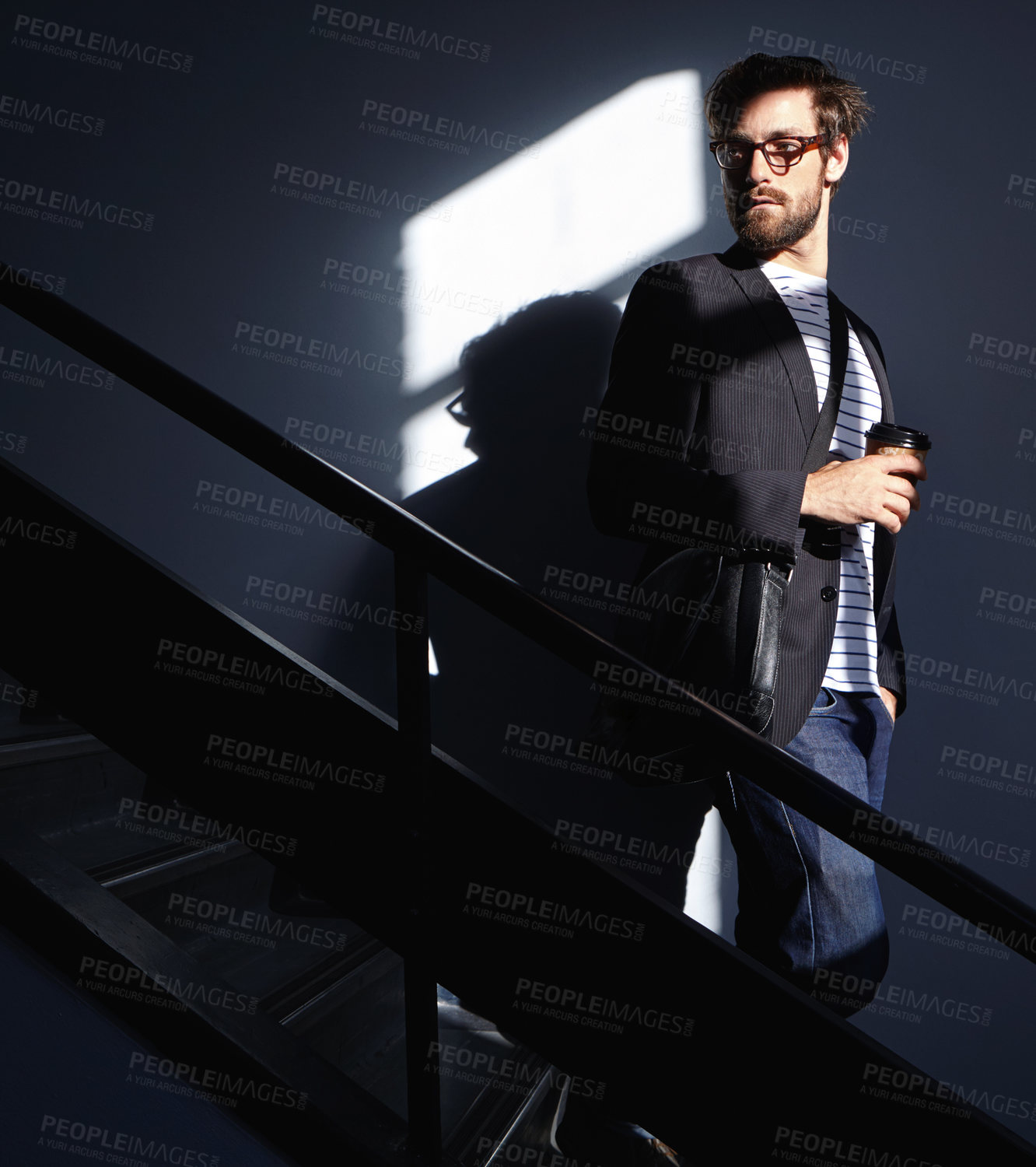 Buy stock photo Shot of a stylish and confident young man walking down a staircase