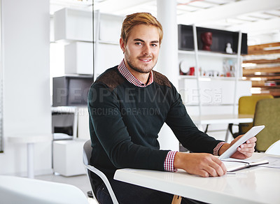 Buy stock photo Cropped portrait of a young businssman using a digital tablet at his desk in the office