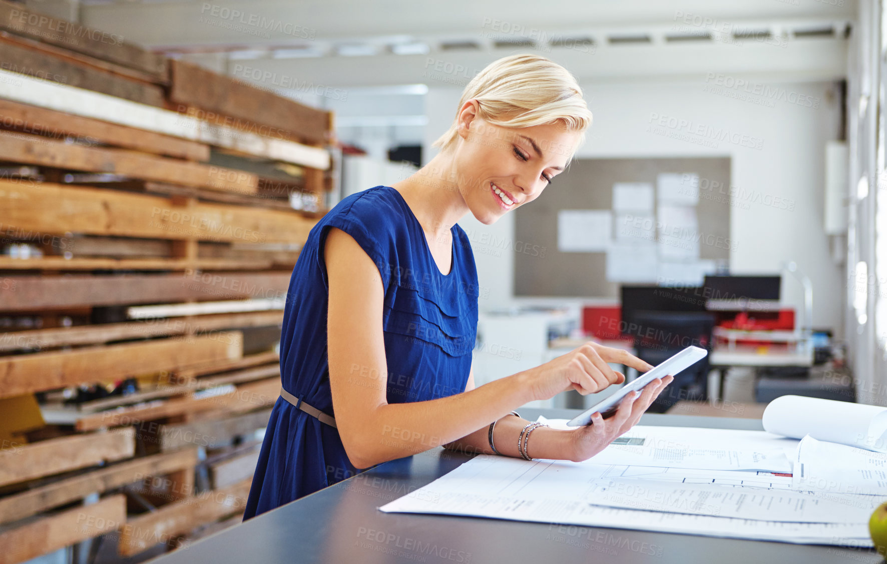 Buy stock photo Cropped shot of a young businesswoman working on her tablet in the office