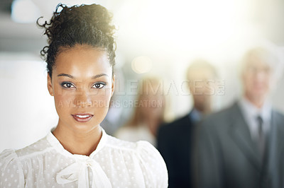 Buy stock photo Cropped portrait of a young businesswoman standing in her office with colleagues in the background