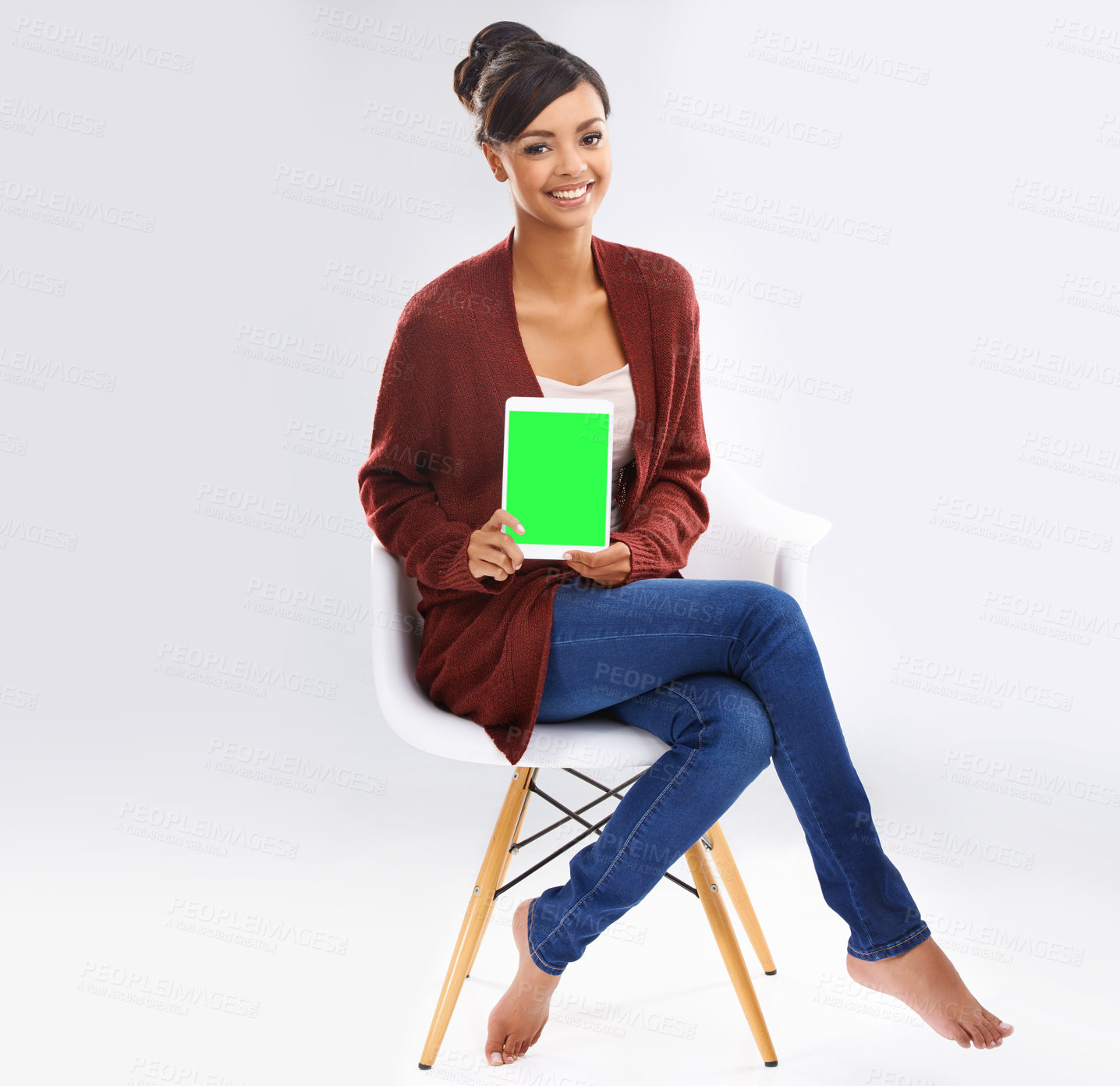 Buy stock photo Studio portrait of an attractive young woman sitting on a chair holding a digital tablet