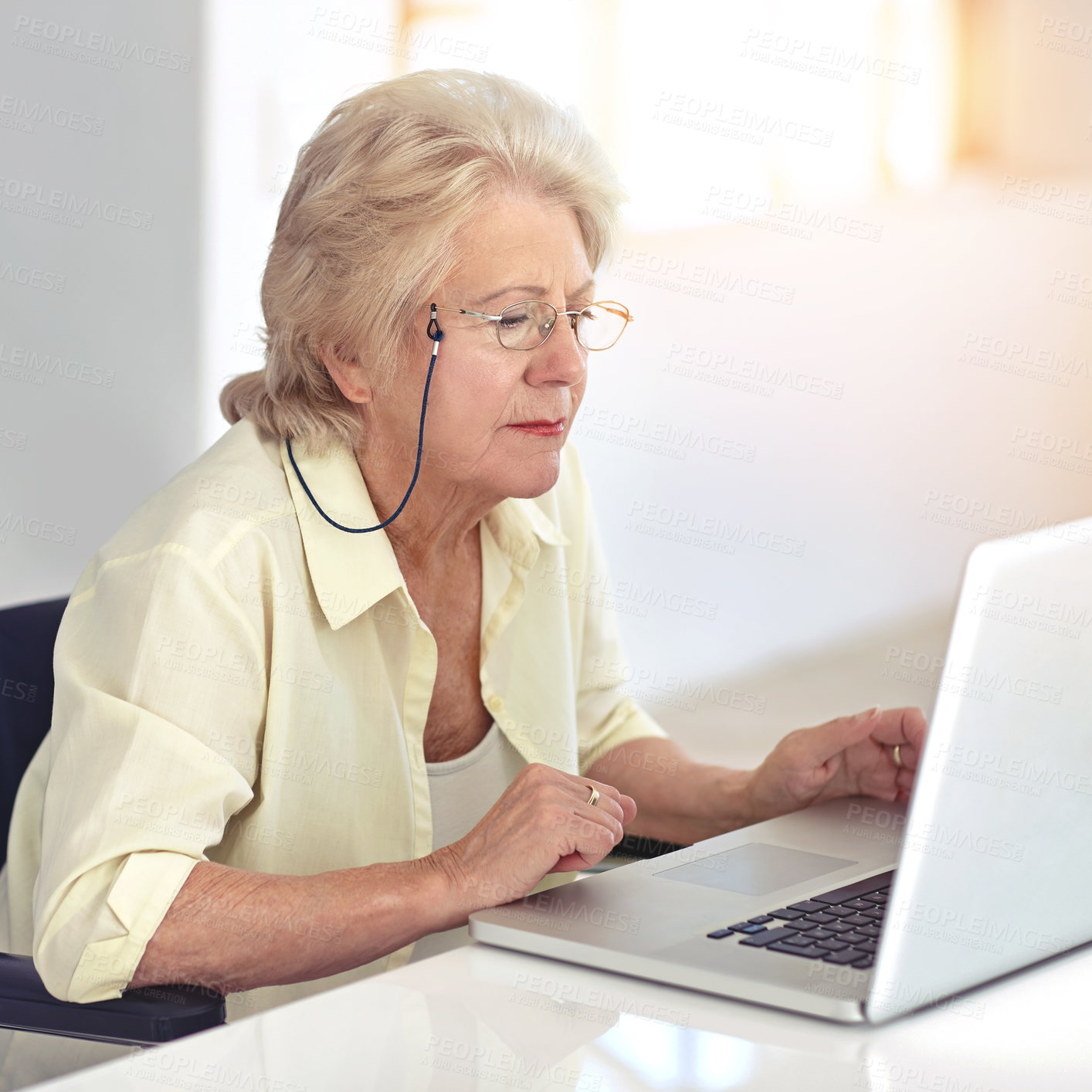 Buy stock photo Cropped shot of a senior woman using her laptop at home