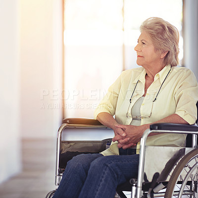 Buy stock photo Shot of a senior woman looking thoughtful while sitting in a wheelchair at home