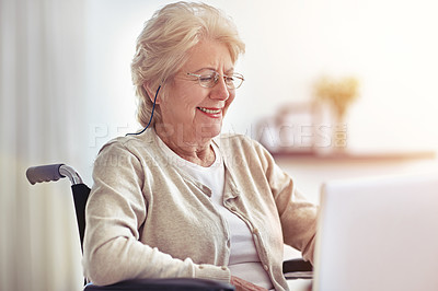 Buy stock photo Shot of a senior woman using a laptop while sitting in a wheelchair