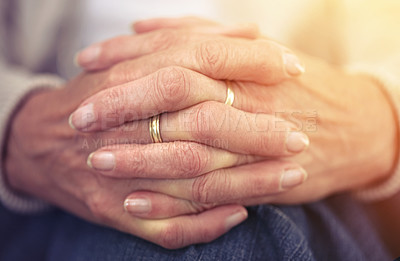 Buy stock photo Hands, retirement and nostalgia with a senior woman closeup indoor thinking about a past memory. Fingers, wrinkles and old age with a mature female pensioner sitting in her home feeling lonely