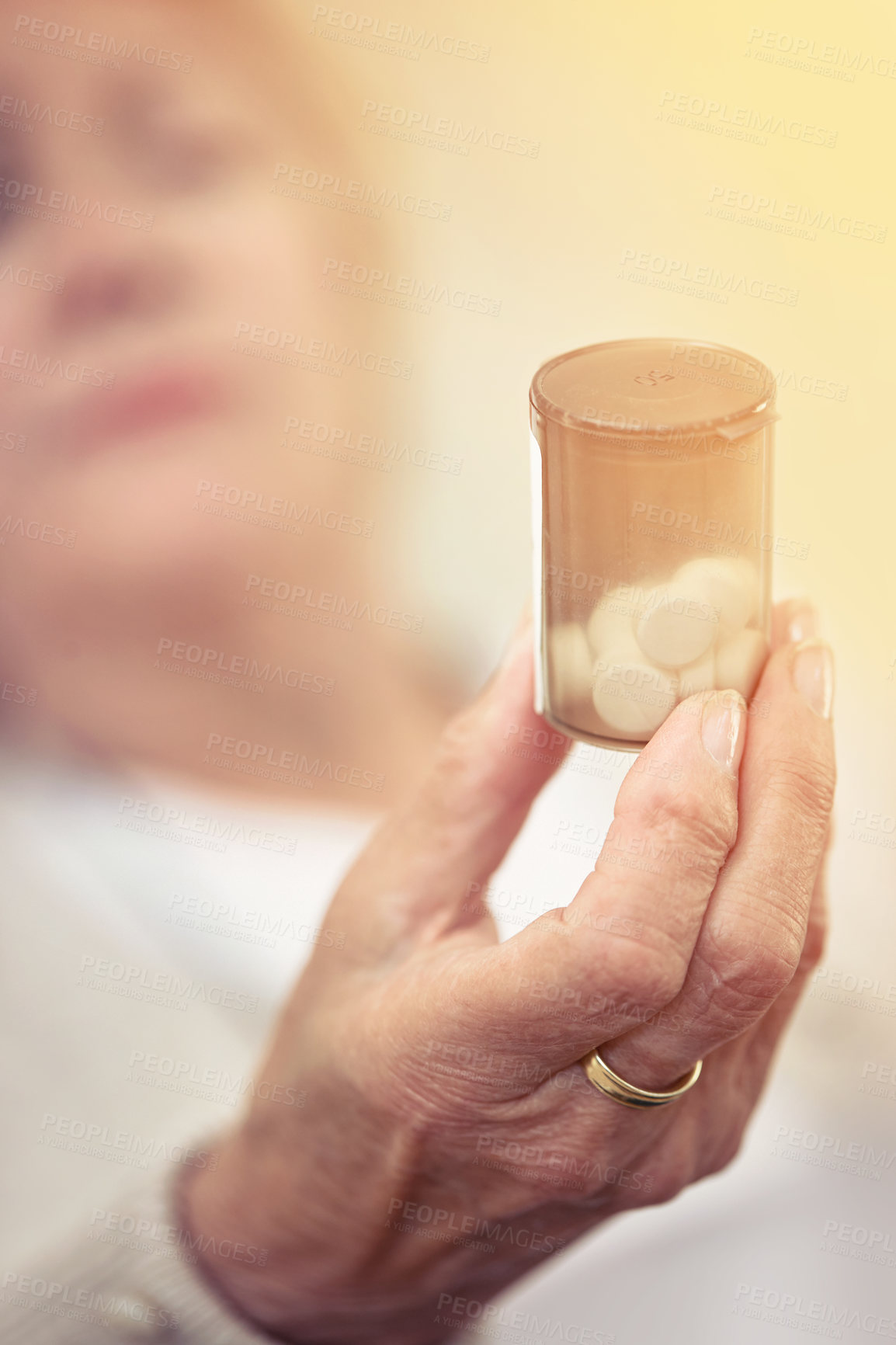 Buy stock photo Cropped shot of an elderly woman holding a container of medicine