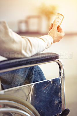 Buy stock photo Cropped shot of a senior woman sitting in a wheelchair holding a container of medincine