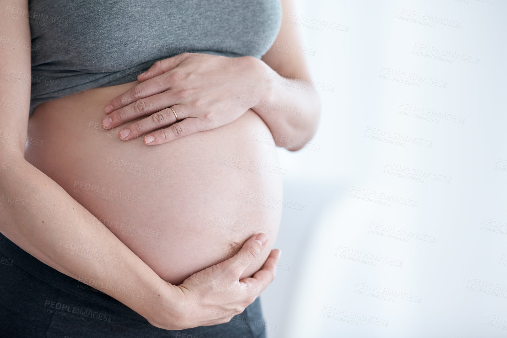 Buy stock photo Cropped shot of a pregnant woman standing in her home