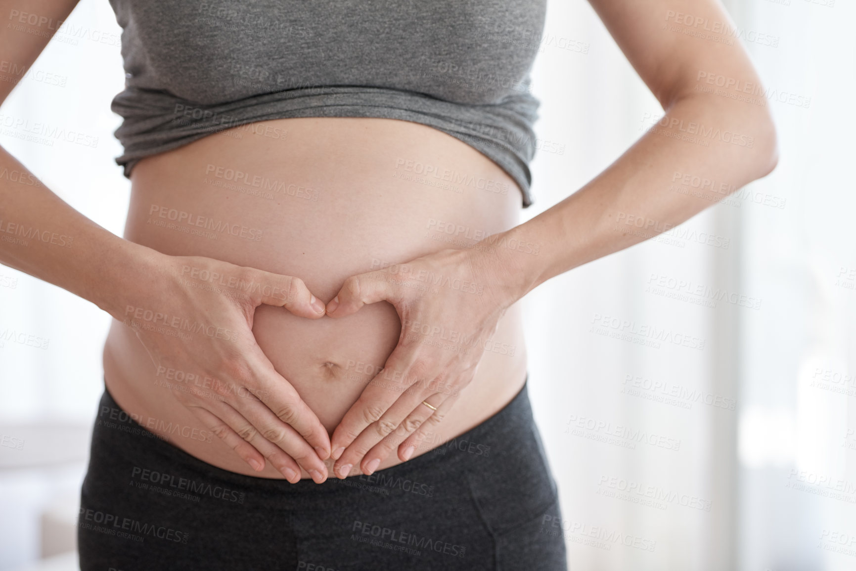 Buy stock photo Cropped shot of a pregnant woman standing in her home