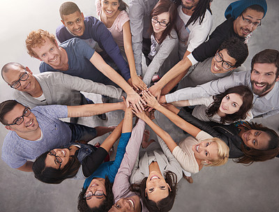 Buy stock photo High angle portrait of a business team standing in a circle with their hands stacked