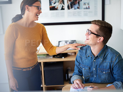 Buy stock photo Shot of two coworkers laughing while having a conversation in the office