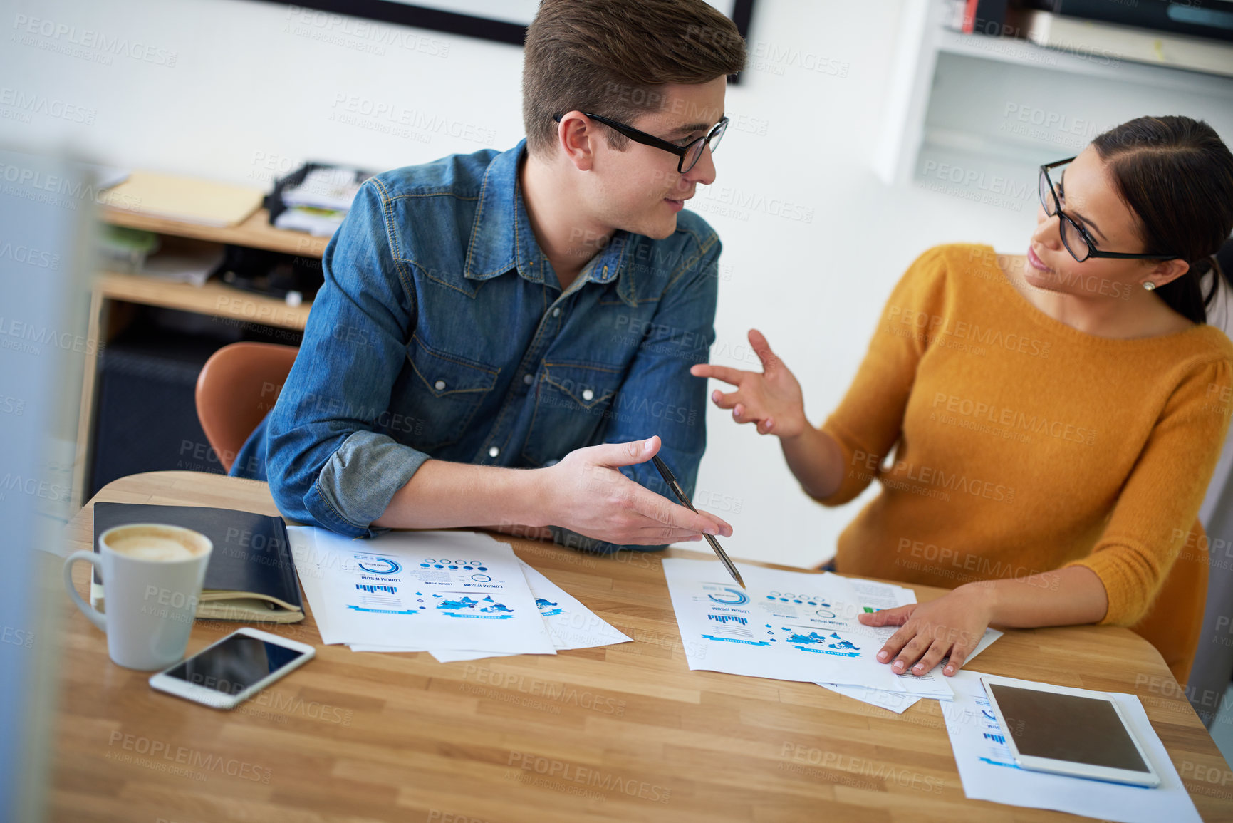 Buy stock photo Cropped shot of two coworkers having a discussion in the office