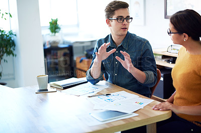 Buy stock photo Cropped shot of two coworkers having a discussion in the office