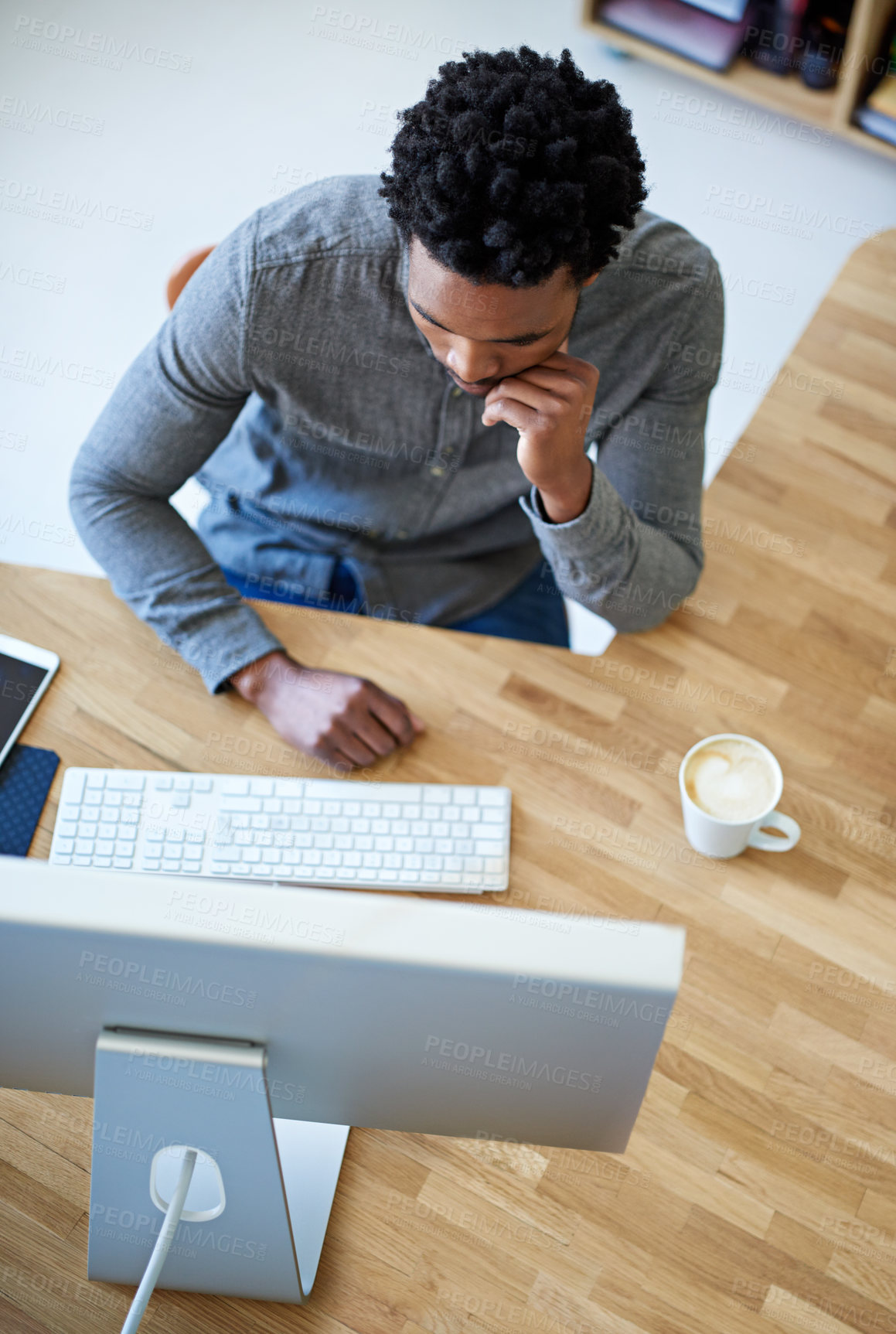 Buy stock photo High angle shot of a young male designer at his desk