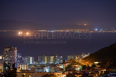 Buy stock photo Night, lights and skyline with buildings by ocean for travel, urban adventure and aerial view of harbour. Dark, cityscape and landscape of sea for vacation, port and residential area in South Africa