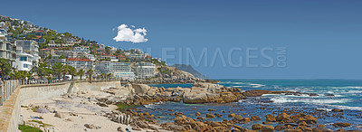 Buy stock photo Landscape, beach and beachfront for travel, holiday and nature with buildings, ocean and sunshine. Coastal view, water and sea in summer for tropical vacation in Cape Town with blue sky and cityscape