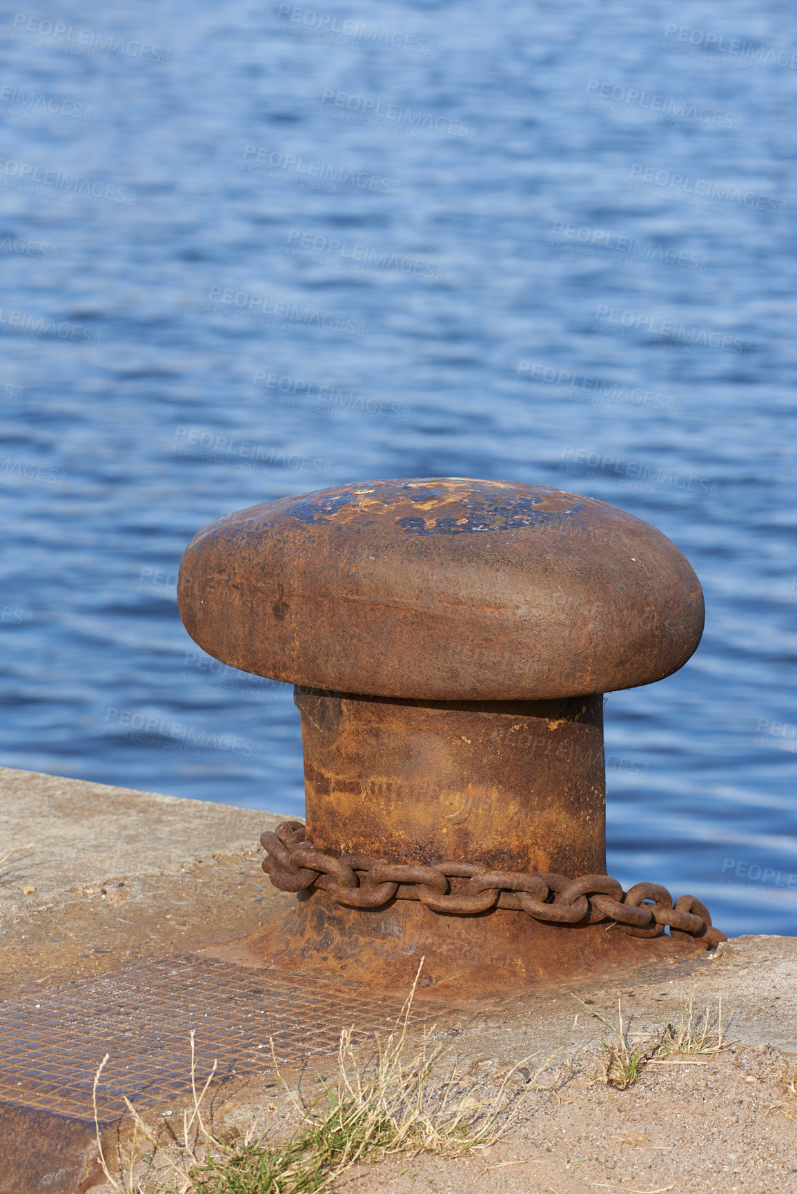 Buy stock photo Iron, bollard and harbor at sea in nature for mooring line, safety and anchoring vessels to secure boat. Maritime, shipping industry and steel pole with rust, chain and water landscape for transport