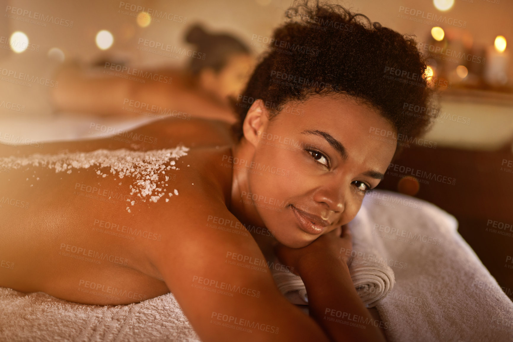 Buy stock photo Salt, spa application and black woman portrait of customer at a hotel with lying for massage. Exfoliate therapy, luxury and relax treatment of a female person back for skincare and wellness 