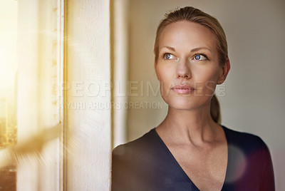 Buy stock photo Cropped shot of a businesswoman looking out of a window in her office