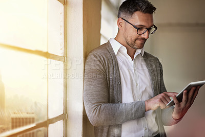 Buy stock photo Cropped shot of a businessman using a digital tablet in his office