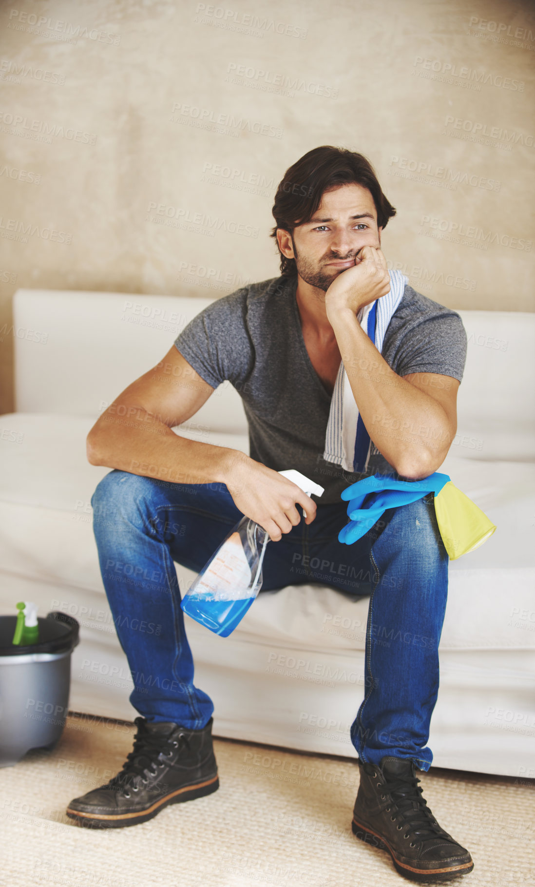 Buy stock photo Shot of a young man taking a break from cleaning the house