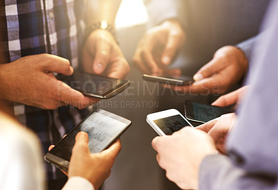 Buy stock photo Shot of coworkers using their digital devices in synchronicity