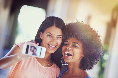 Buy stock photo Shot of two girlfriends taking a selfie on a mobile phone