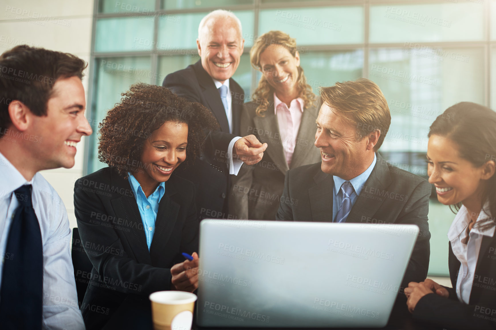 Buy stock photo Cropped shot of a group of businesspeople gathered around a laptop in the office