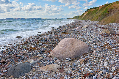 Buy stock photo Coast of Kattegat - Helgenaes, Denmark. Ocean waves washing onto empty beach shore stones. Calm peaceful paradise of summer seascape and sky for relaxing fun holiday abroad or travel vacation