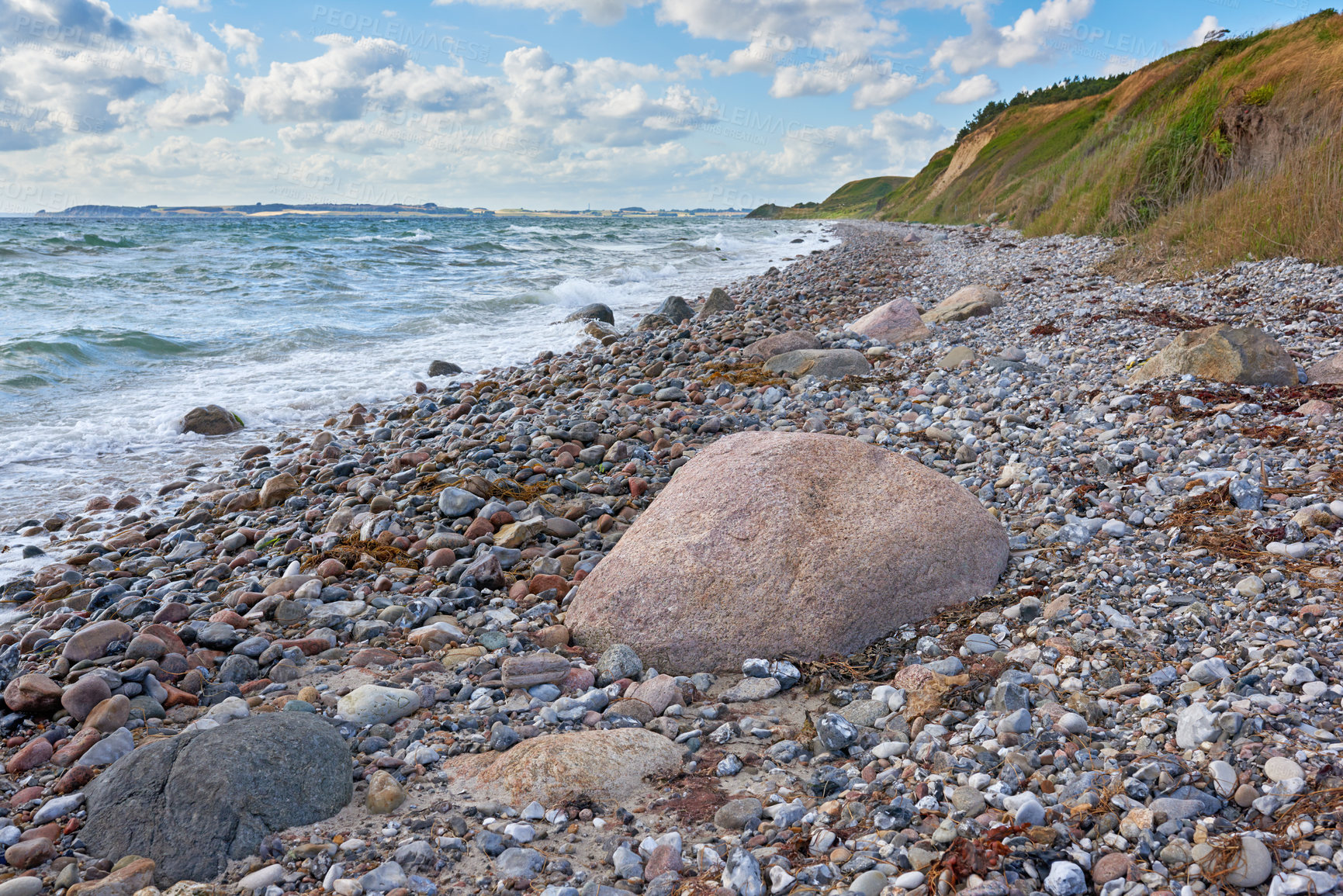 Buy stock photo Coast of Kattegat - Helgenaes, Denmark. Ocean waves washing onto empty beach shore stones. Calm peaceful paradise of summer seascape and sky for relaxing fun holiday abroad or travel vacation