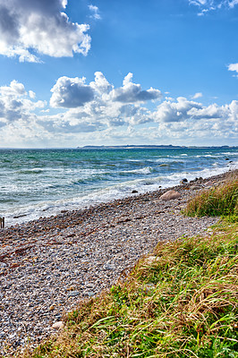 Buy stock photo Sea, waves and nature beach or outside, coastal geology and shore for sea level observation of human impacts. Tides, ocean health and sky background with clouds in winter, plants and lush vegetation