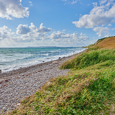 Buy stock photo Ocean, waves and nature beach or outside, coastal geology and shore for sea level observation of human impacts. Tides, sea health and sky background with clouds in winter, plants and lush vegetation