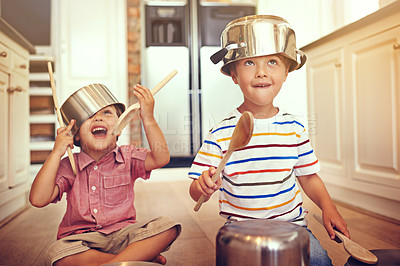 Buy stock photo Two young boys sitting on the kitchen floor playing with pots and pans