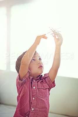 Buy stock photo Children, toys and boy playing with helicopter in a house for fun, curious or morning games in his home. Plane, flying or kid in a living room with aircraft model, dreaming or future pilot fantasy