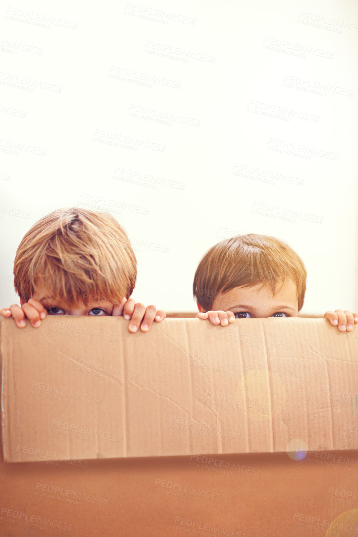 Buy stock photo Box, kids and eyes of siblings playing in a house with fun, bonding and hide and seek games. Cardboard, learning and curious boy children in a living room with fantasy, imagine or hiding at home