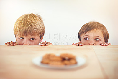 Buy stock photo Two little boys sneakily trying to take a cookie from a plate