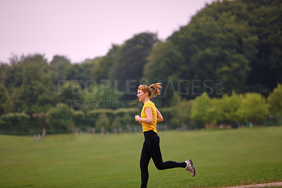 Buy stock photo Shot of a woman jogging in a park