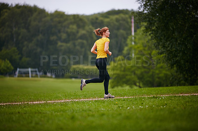 Buy stock photo Shot of a woman jogging along a foothpath in a park