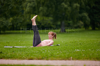 Buy stock photo Shot of a woman doing yoga in the park