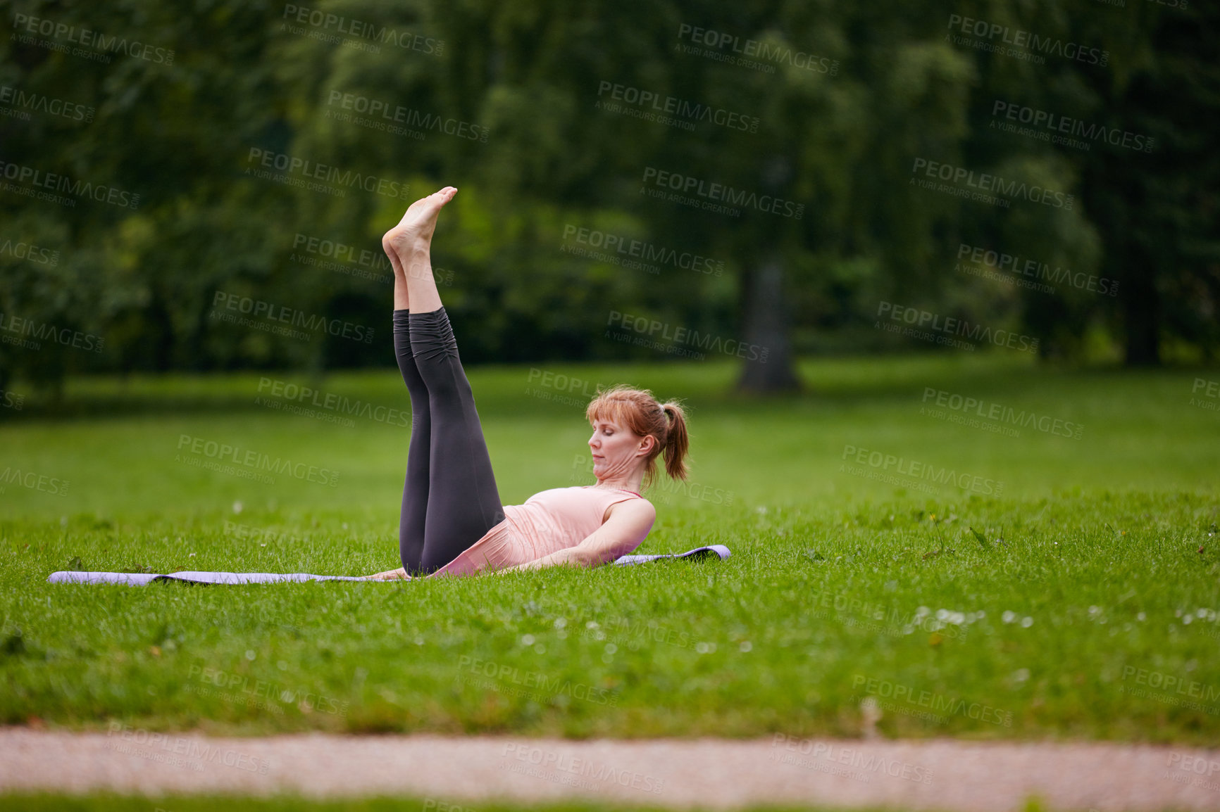 Buy stock photo Shot of a woman doing yoga in the park