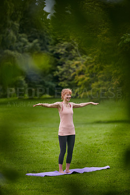 Buy stock photo Shot of a woman doing yoga in the park