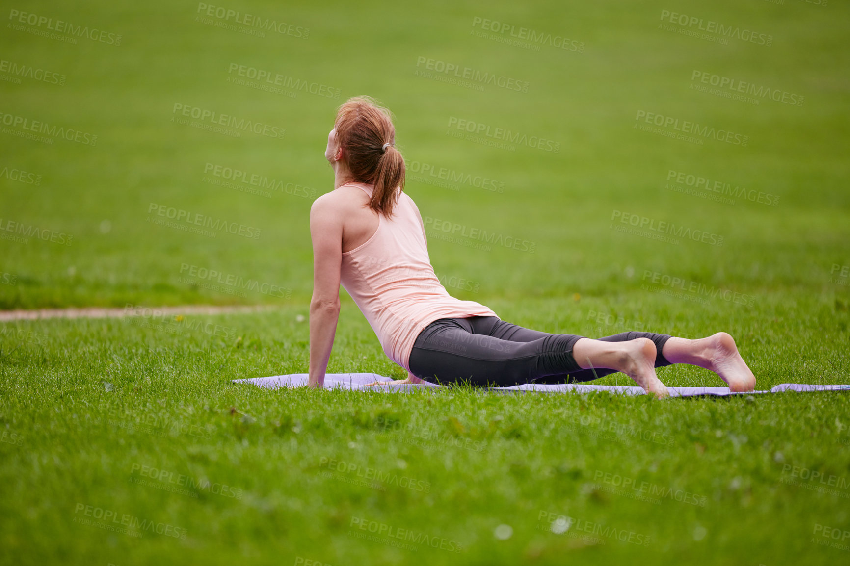 Buy stock photo Shot of a woman doing yoga in the park