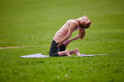 Buy stock photo Shot of a woman practicing yoga in a park