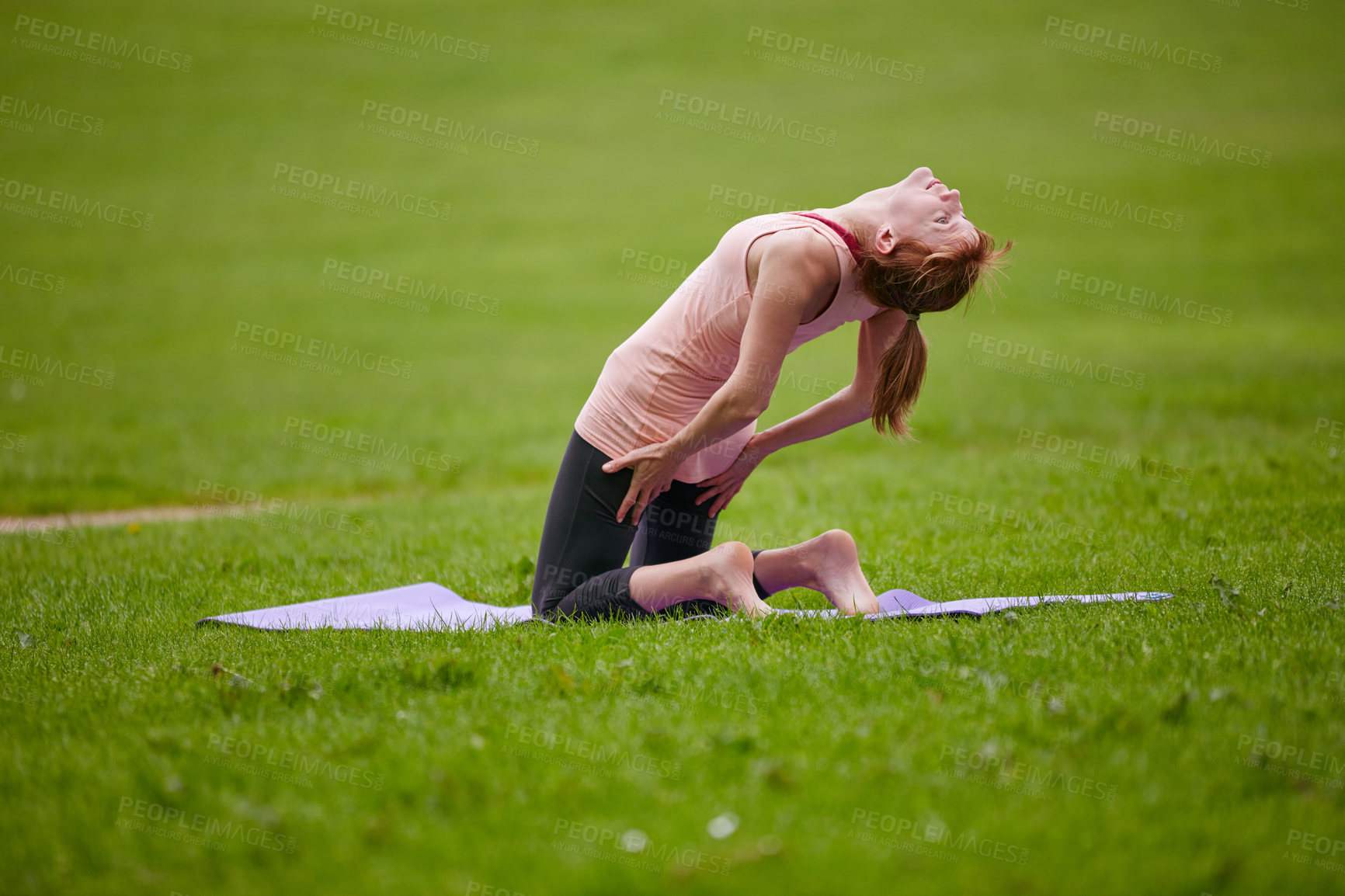 Buy stock photo Shot of a woman practicing yoga in a park