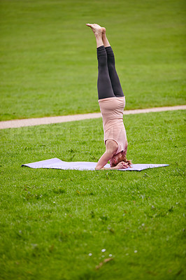 Buy stock photo Shot of a woman doing yoga in the park