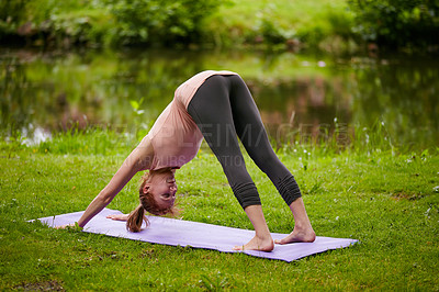 Buy stock photo Shot of a woman doing yoga in the park