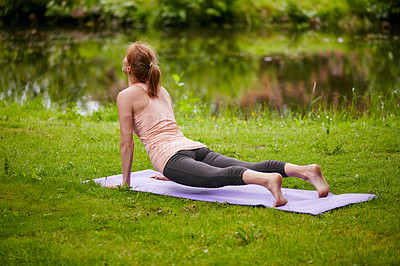 Buy stock photo Shot of a woman doing yoga in the park