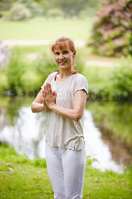 Buy stock photo Shot of a woman doing yoga in the park