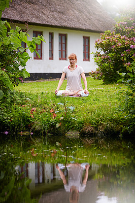 Buy stock photo Shot of a woman sitting in the lotus position in her backyard