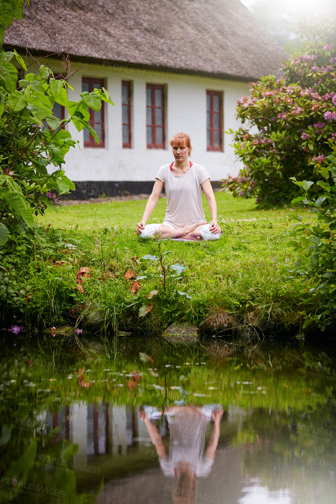 Buy stock photo Shot of a woman sitting in the lotus position in her backyard